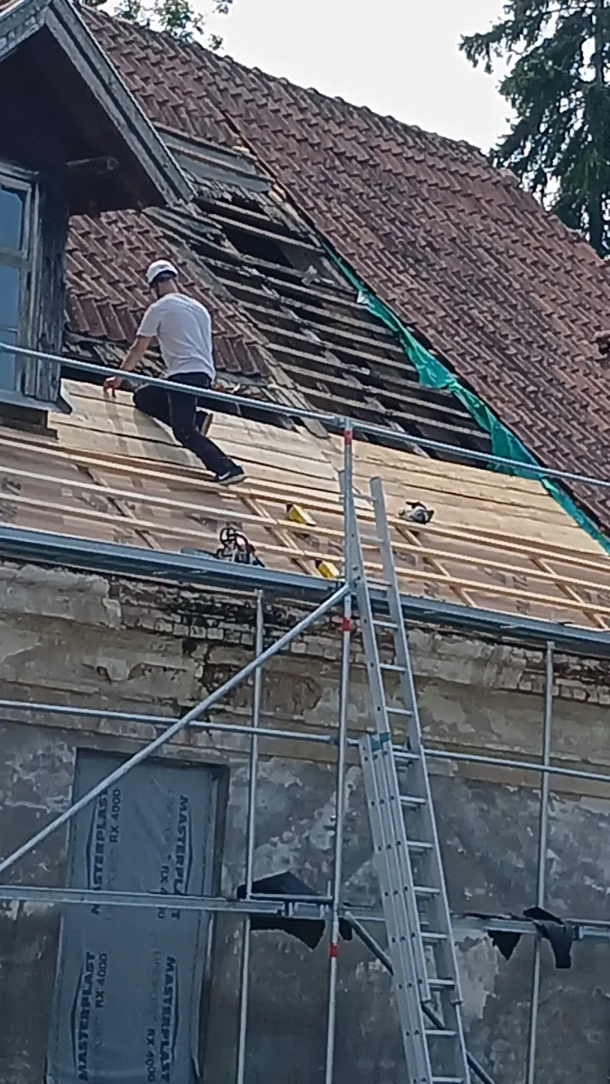 A volunteer working on the roof of Dižstende Idea Manor in Talsi, Latvia